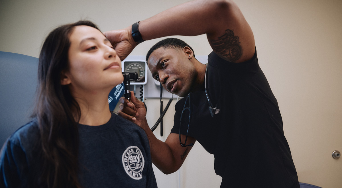 Isaac works his civilian job taking a patients vitals