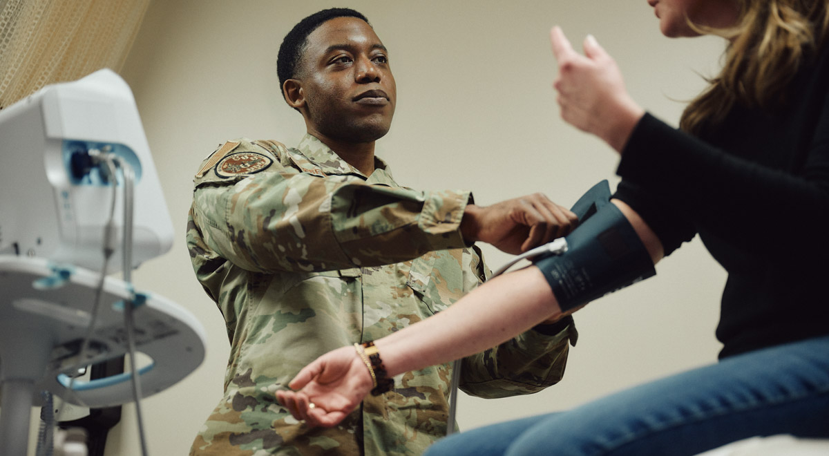 Isaac checks a patient's blood pressure