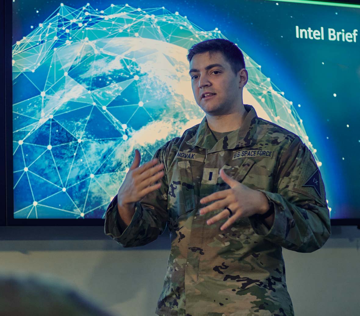 jon stands in front of a screen presenting to colleagues