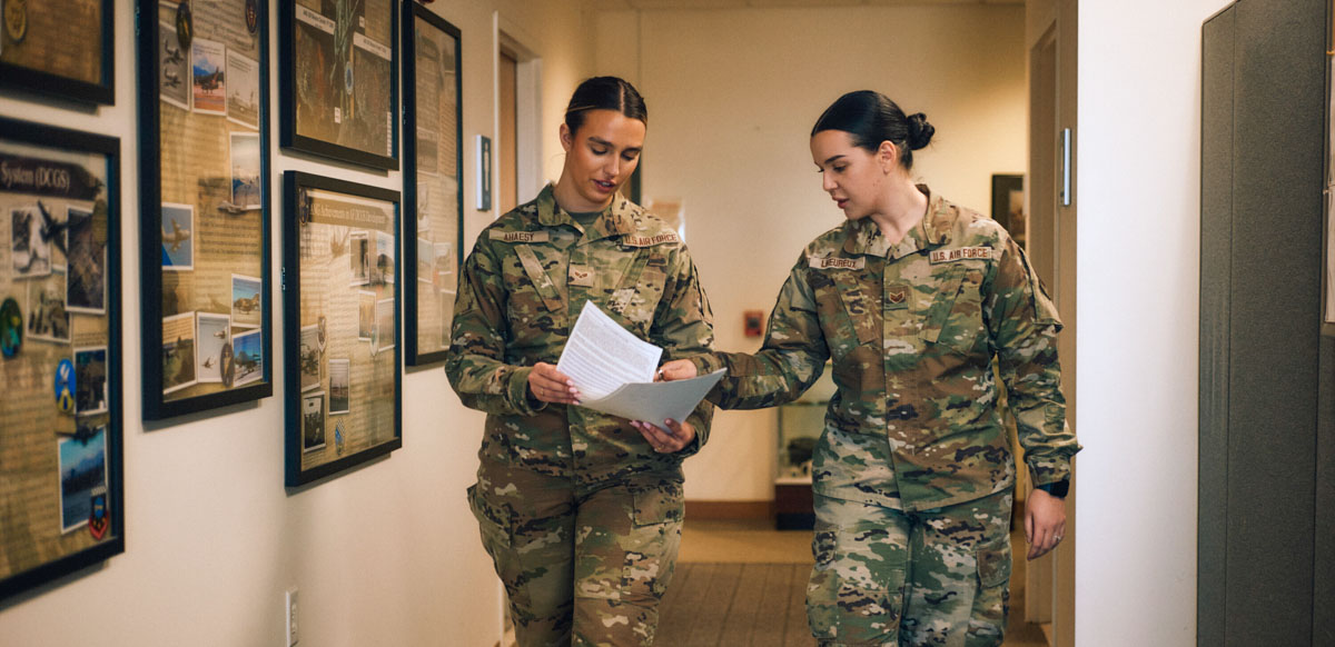 Laura-Kate and a work colleague in uniform reviewing paperwork in the hallway