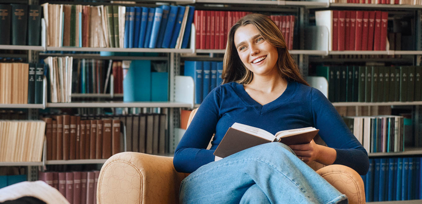 laura-kate chats with a classmate in the university library