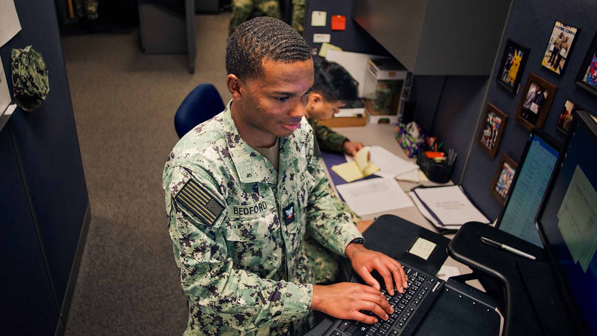 Julian Bedford at a computer with a fellow service member working