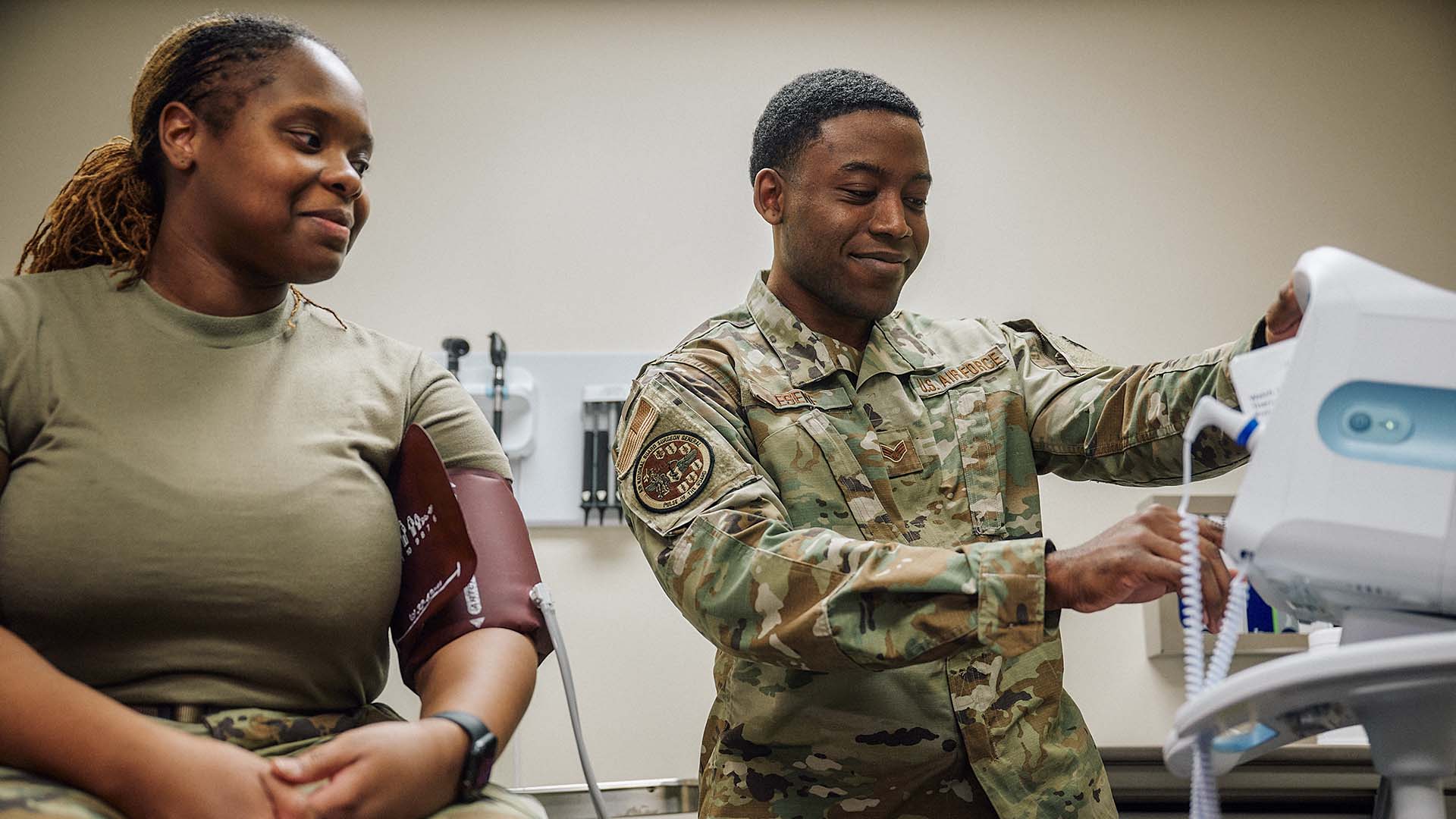 Isaac Esene checking a patients blood pressure 