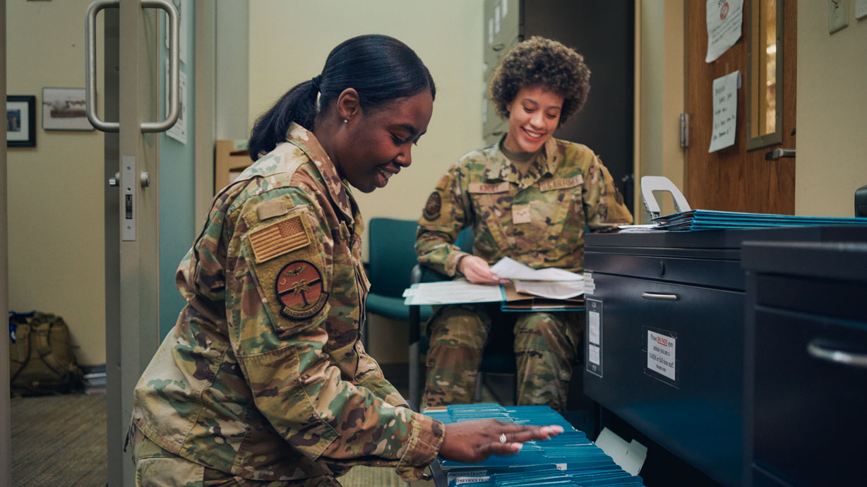 contract specialists review documents in filing cabinets