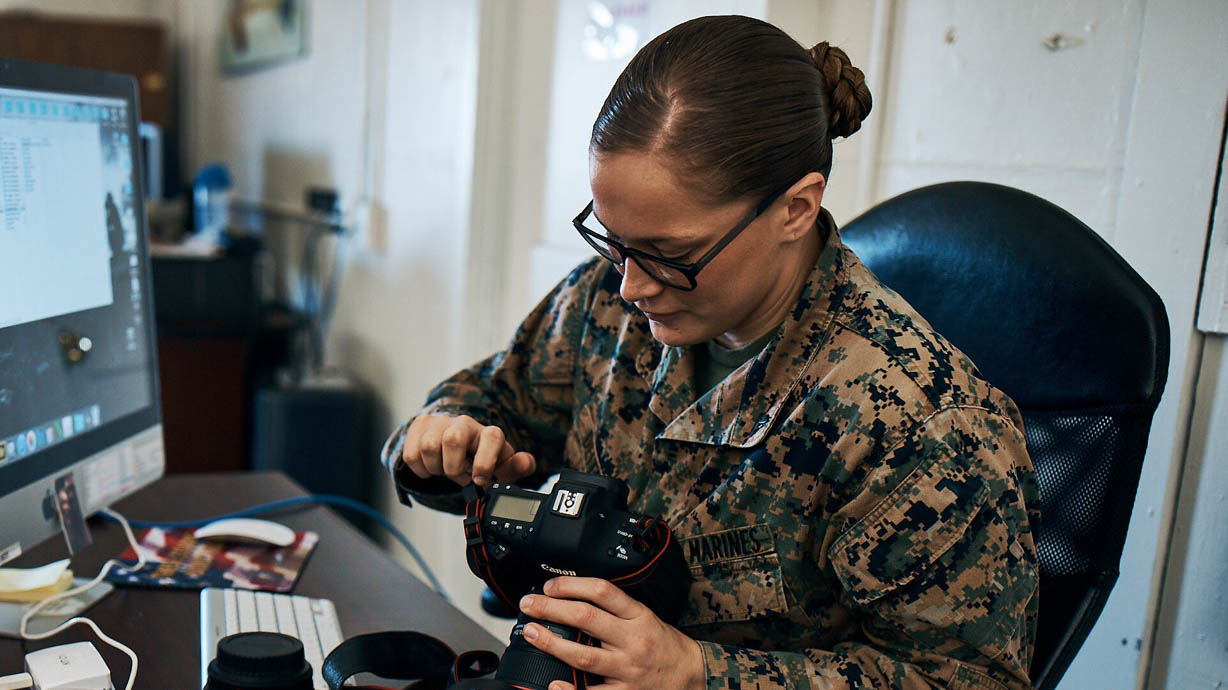 Marine photographer works with cameras at her desk