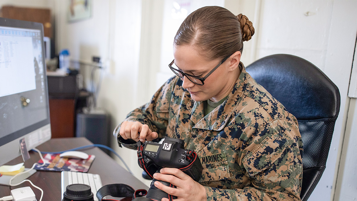 Marine photographer works with cameras at her desk
