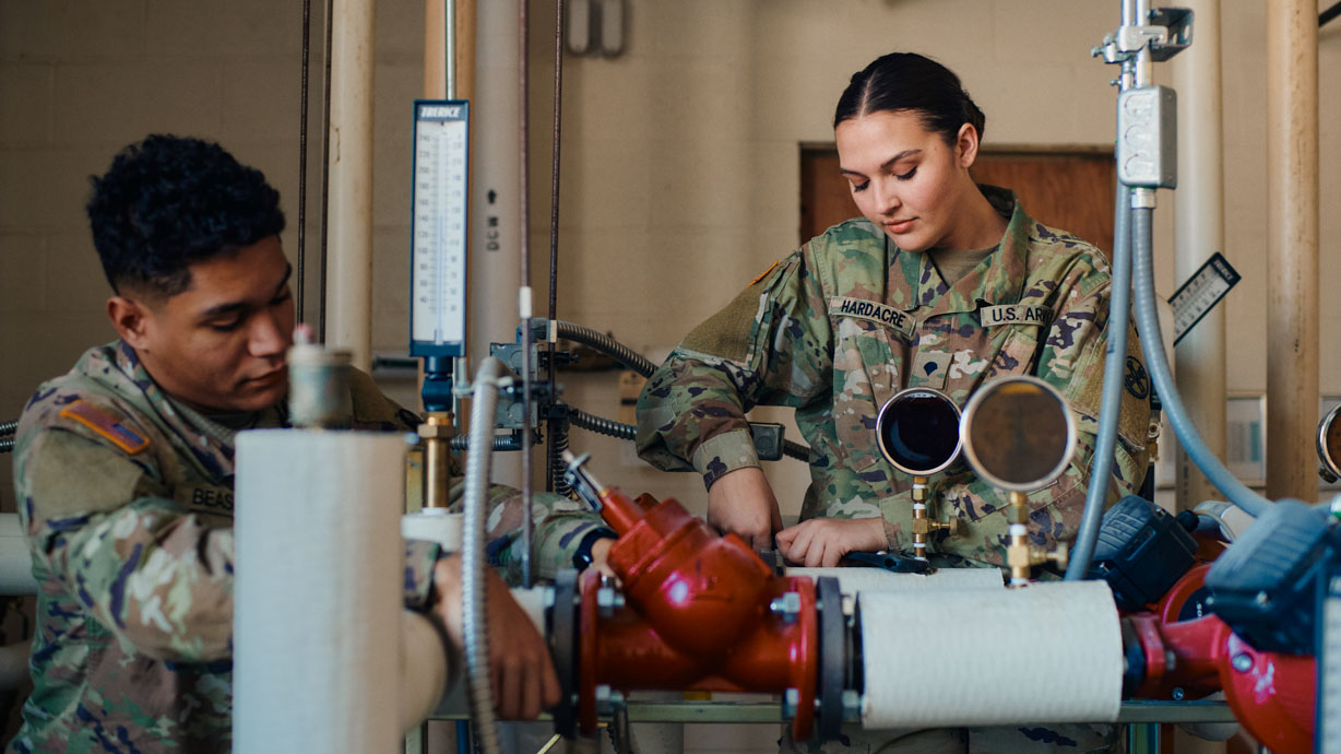 Army plumber working on pipes
