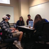 Students sitting around a table smiling
