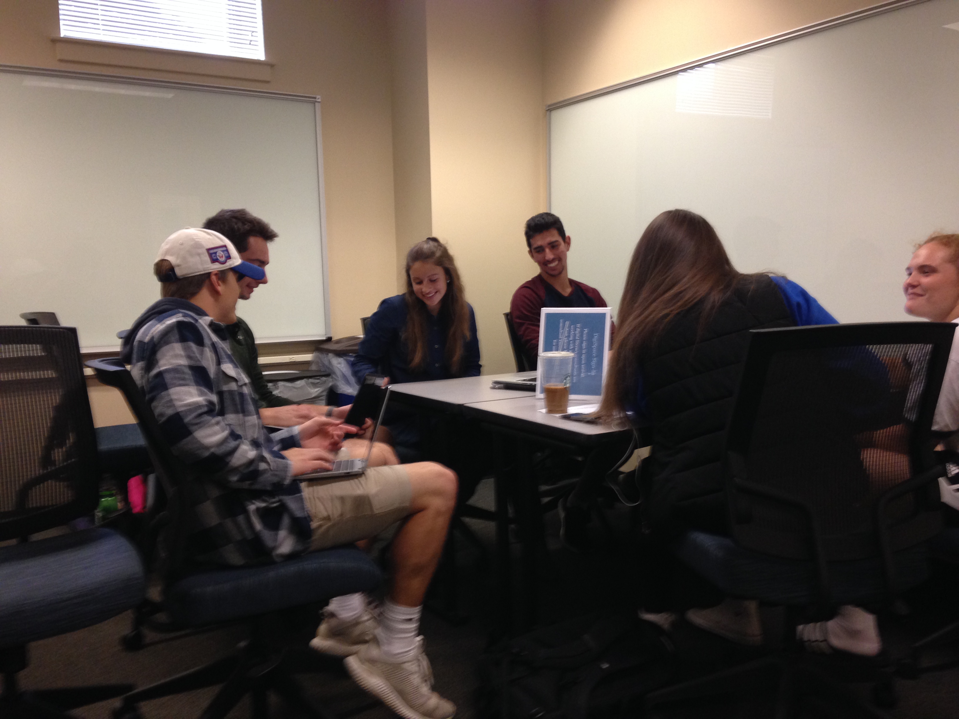 Students sitting around a table smiling