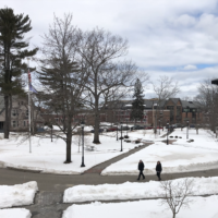 Snowy Portland campus with people walking and clouds covering most of sky