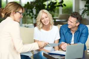 Couple on couch taking with real estate agent