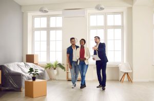 male real estate agent showing a home to a young couple