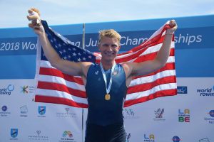 Clark Dean rower holding up flag after winning gold 
