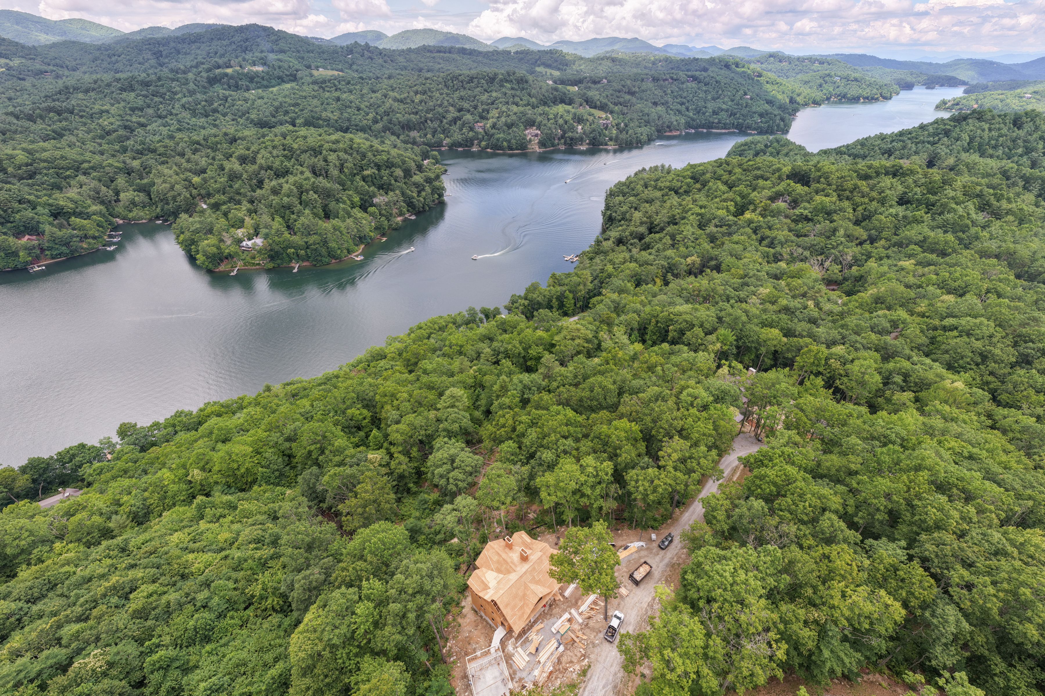 Aerial view of 266 S Ridgeline Road under construction on a wooded ridge above Lake Glenville