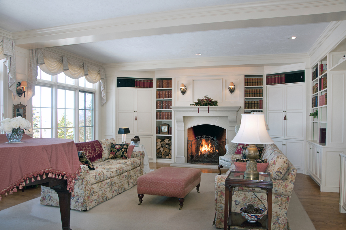Built-in bookshelves and cabinetry and fireplace with mantle