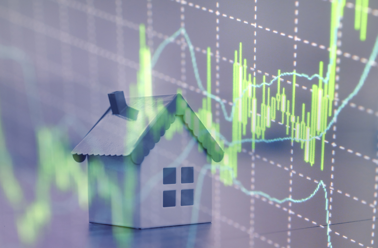 real estate market predictions concept; miniature house with graph in the background