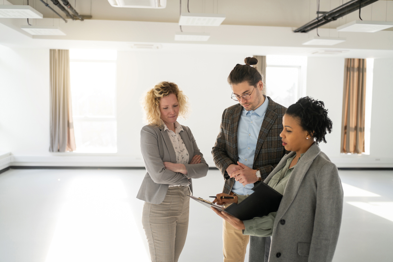 A female real estate agent is explaining the property to her client. Developing a personal branding strategy