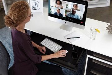 woman sitting on ergonomic chair using apple computer