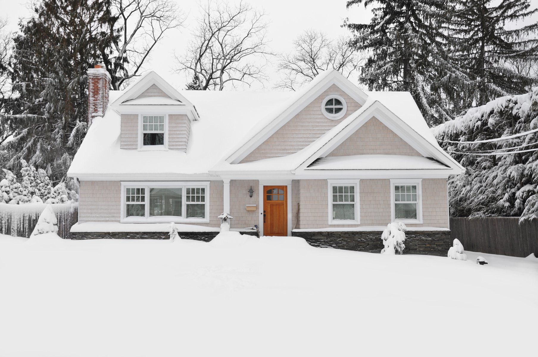 house and snow covered yard trees