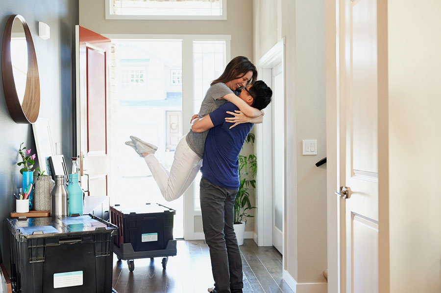 Man and woman hugging in entryway of home