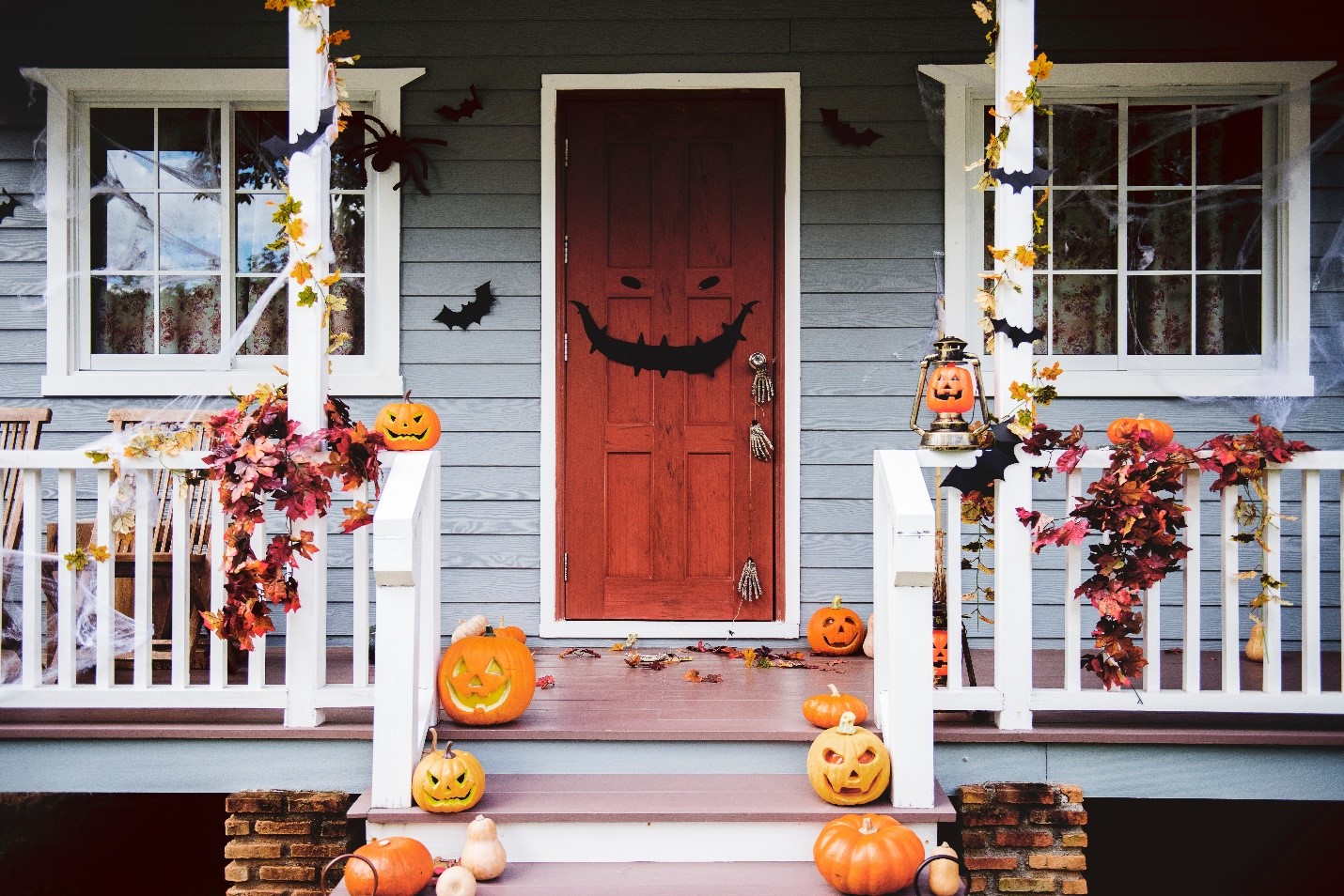 Porch decorated with pumpkins, paper bats