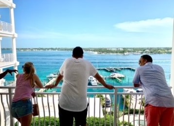 people looking over balcony at view of the ocean