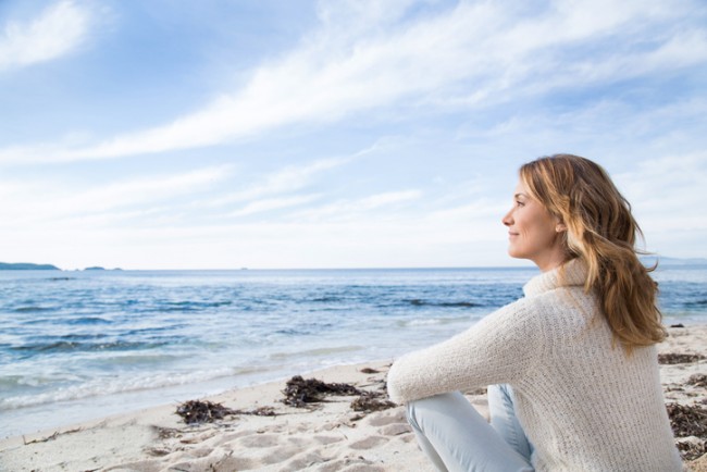 woman sitting on the beach in winter
