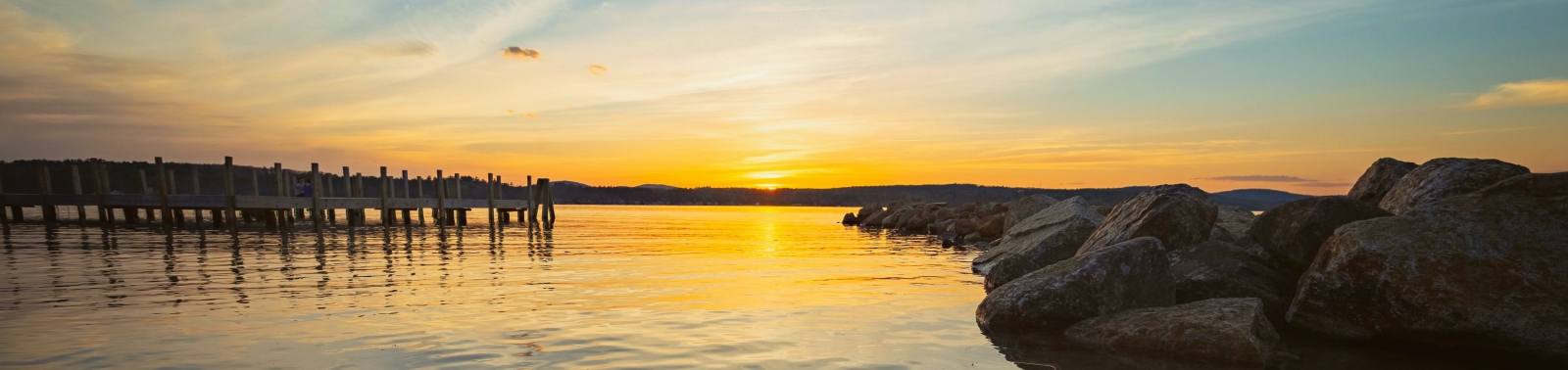 Sunset over rocky lake shore