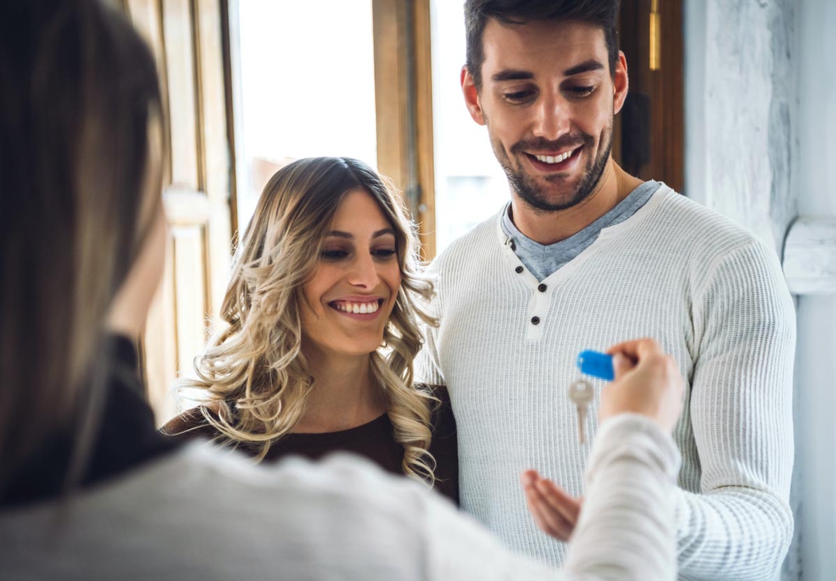 couple accepting house keys from Realtor