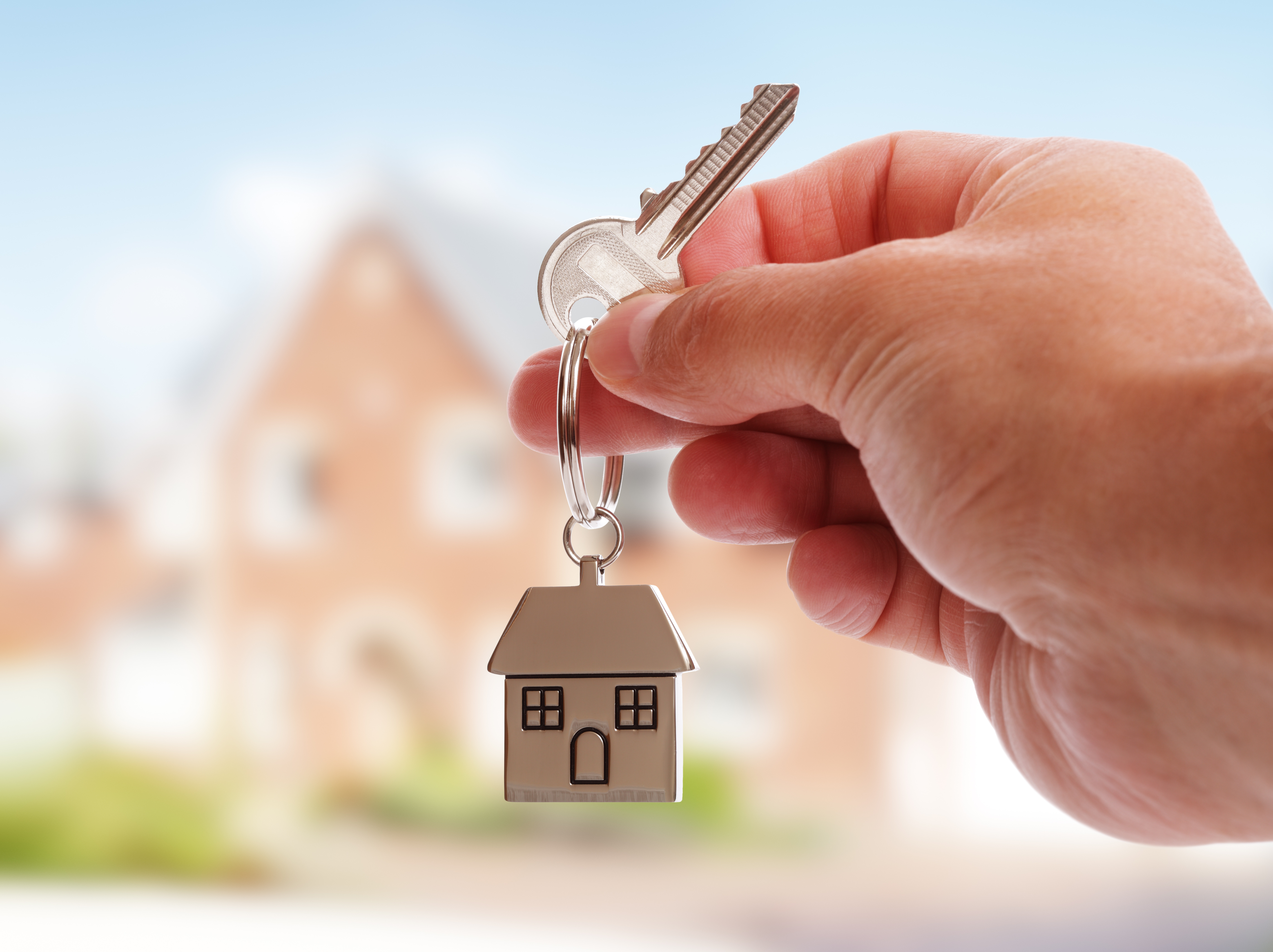 A pair of house keys being handed over after selling your Vermont home