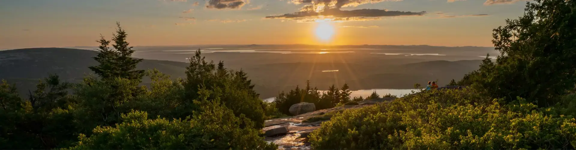 Sunrise over lake surrounded by mountains