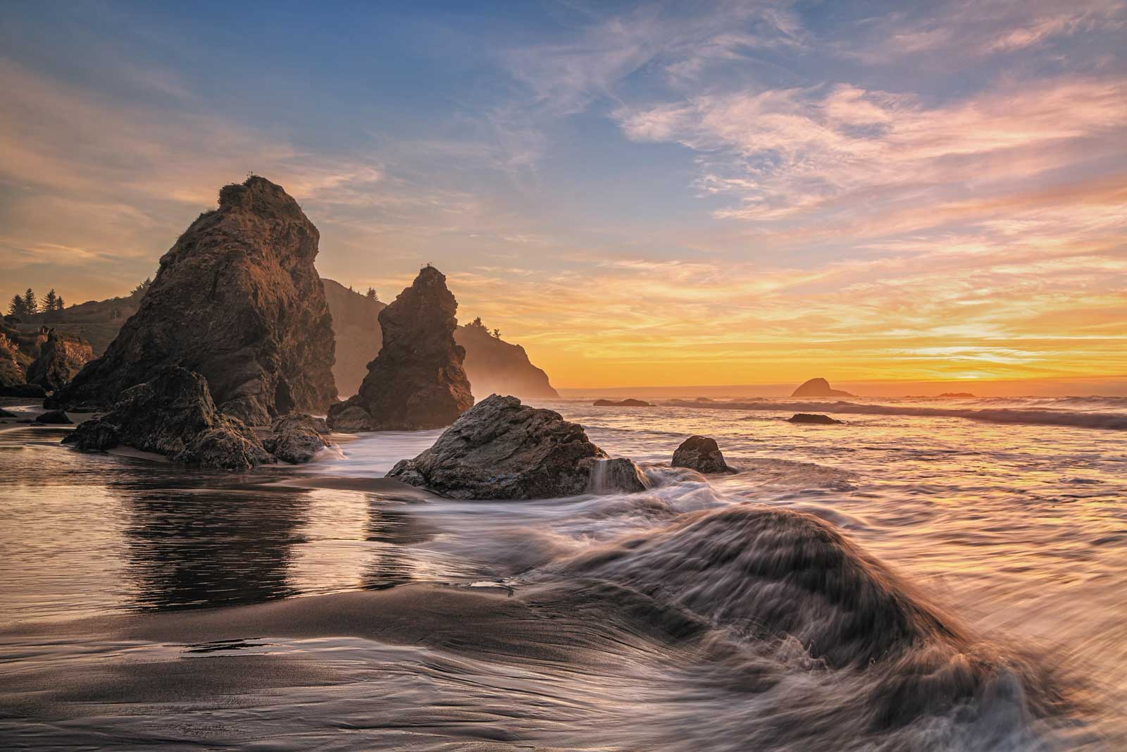 water crashing on ocean rocks at sunset