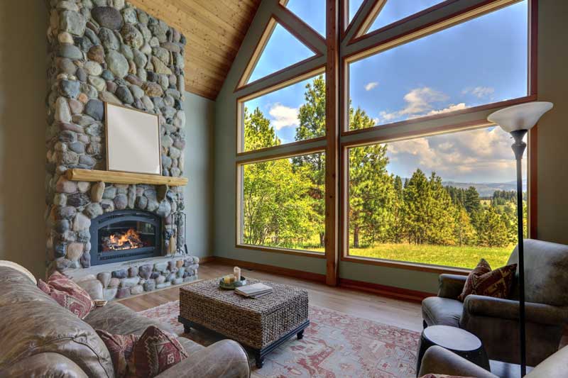 mountain home living room with big window and fireplace
