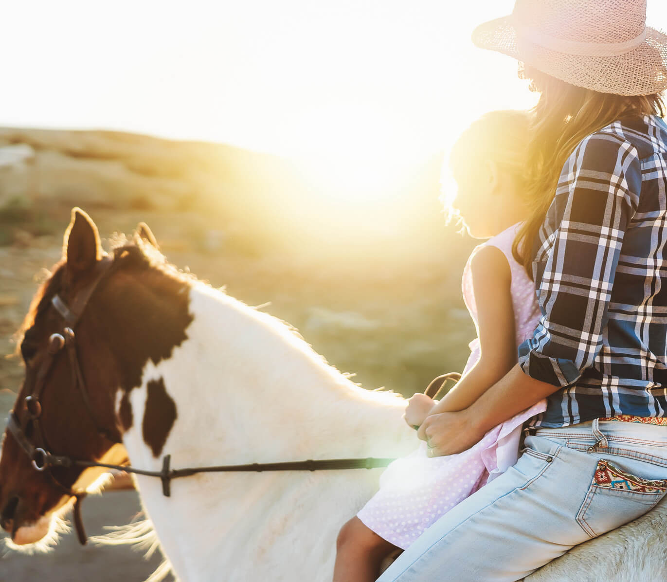 mother and daughter are horseback riding