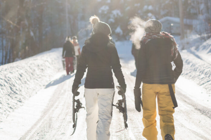 the couple is walking in the winter forest