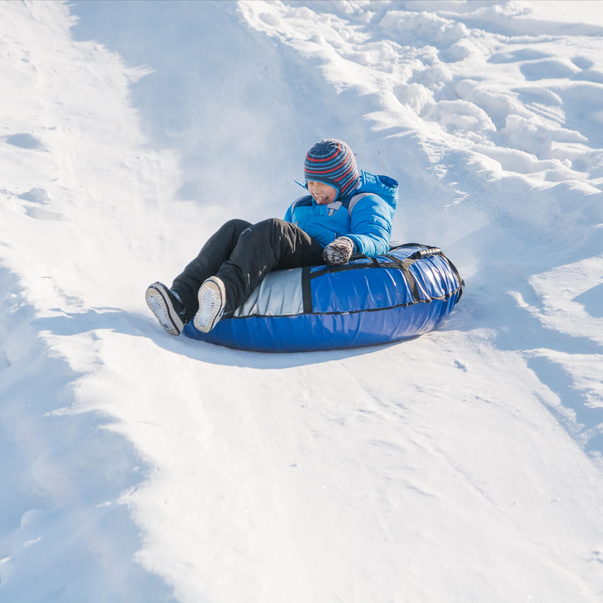 the child is tubing from the hill