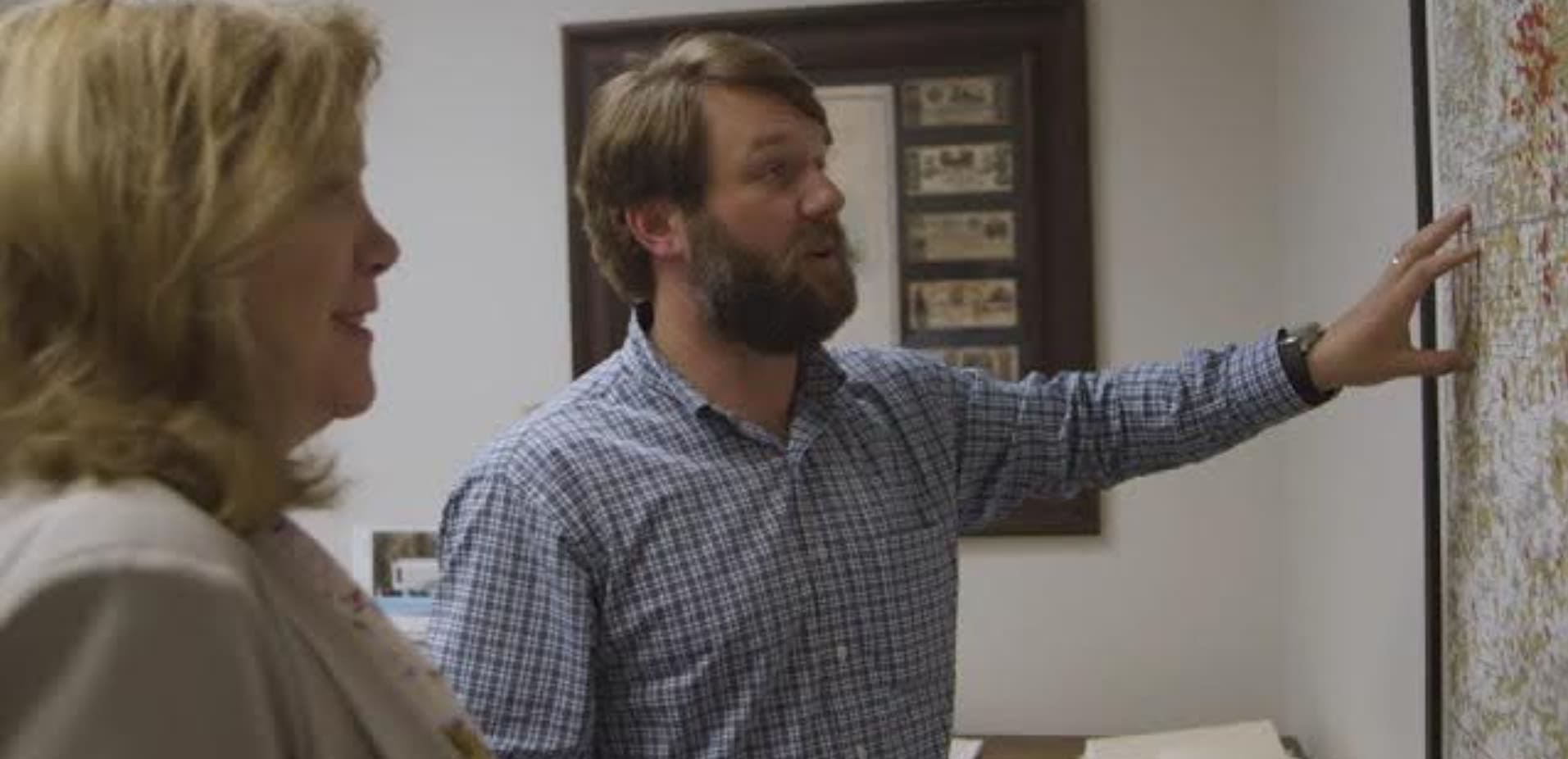 The man is presenting something to the woman