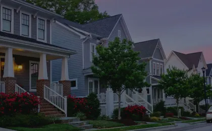 neighborhood street at sunset with dark colored houses at angled view