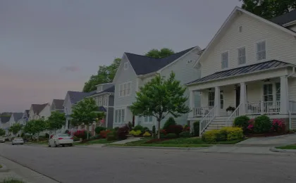 neighborhood street at sunset with light colored houses at angled view