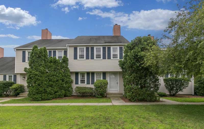 tan condo building with lawn and shrubbery