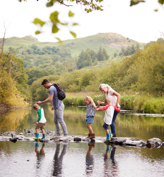 Family walking  across shallow stream