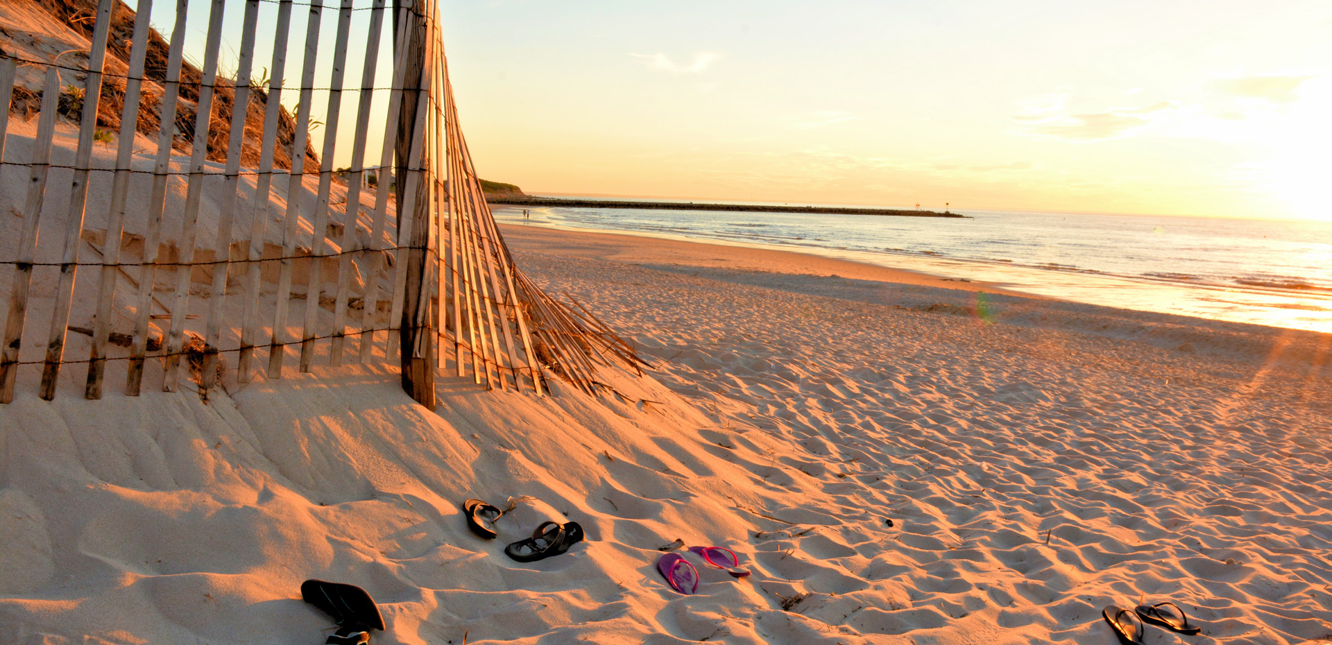 Fence bordering a sandy beach