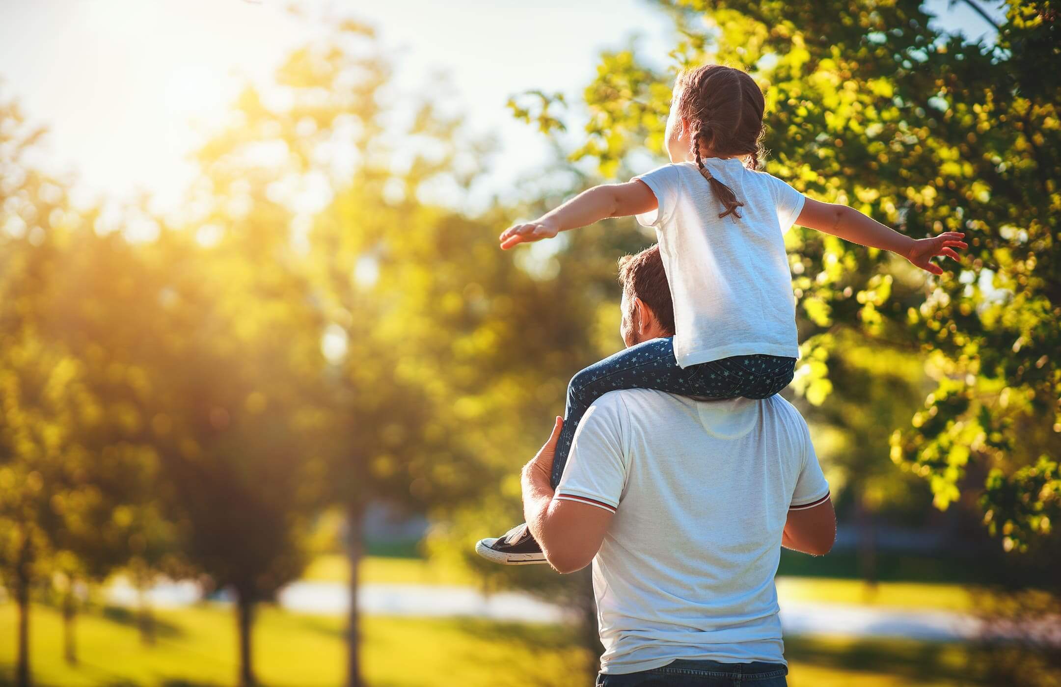 child on father's shoulders while on a walk