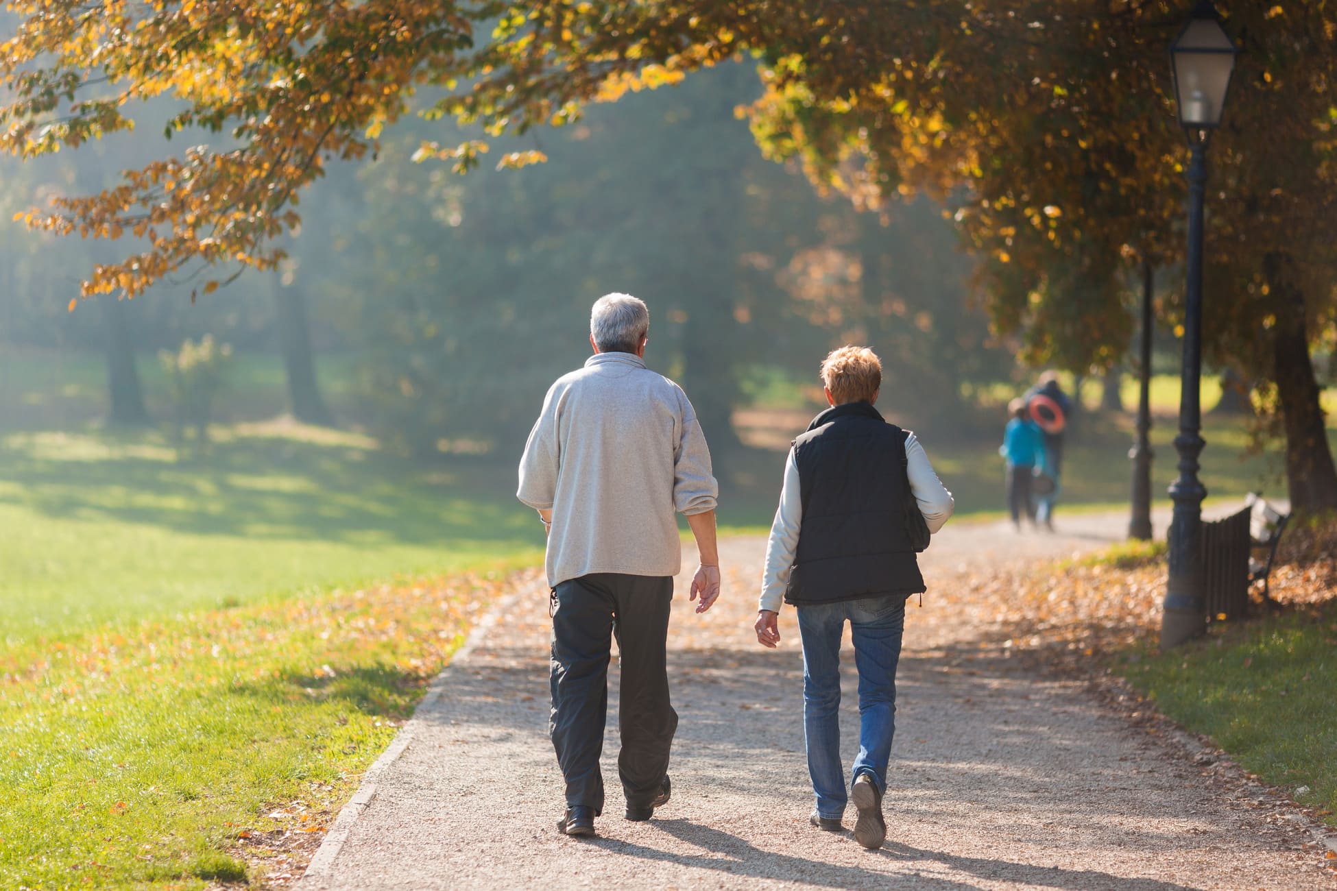 Couple taking a walk in a park during autumn morning.