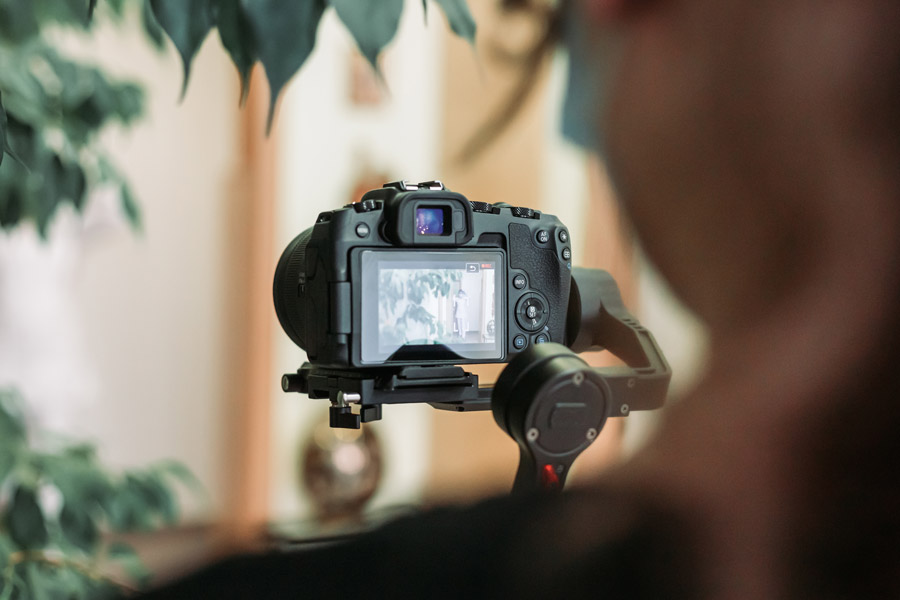 Videographer recording video on the site with mirrorless camera using gimbal