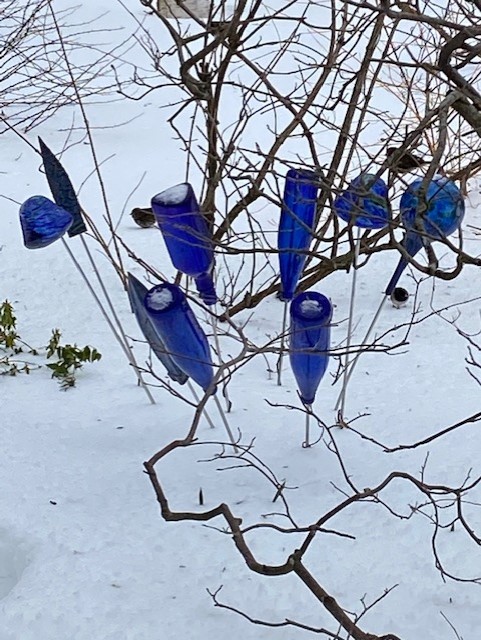Decoración de jardín hecha de botellas de vidrio azul.