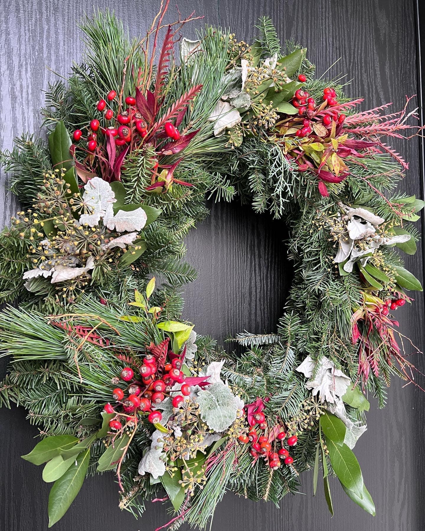 winter wreath with red berries, red foliage, and silver foliage