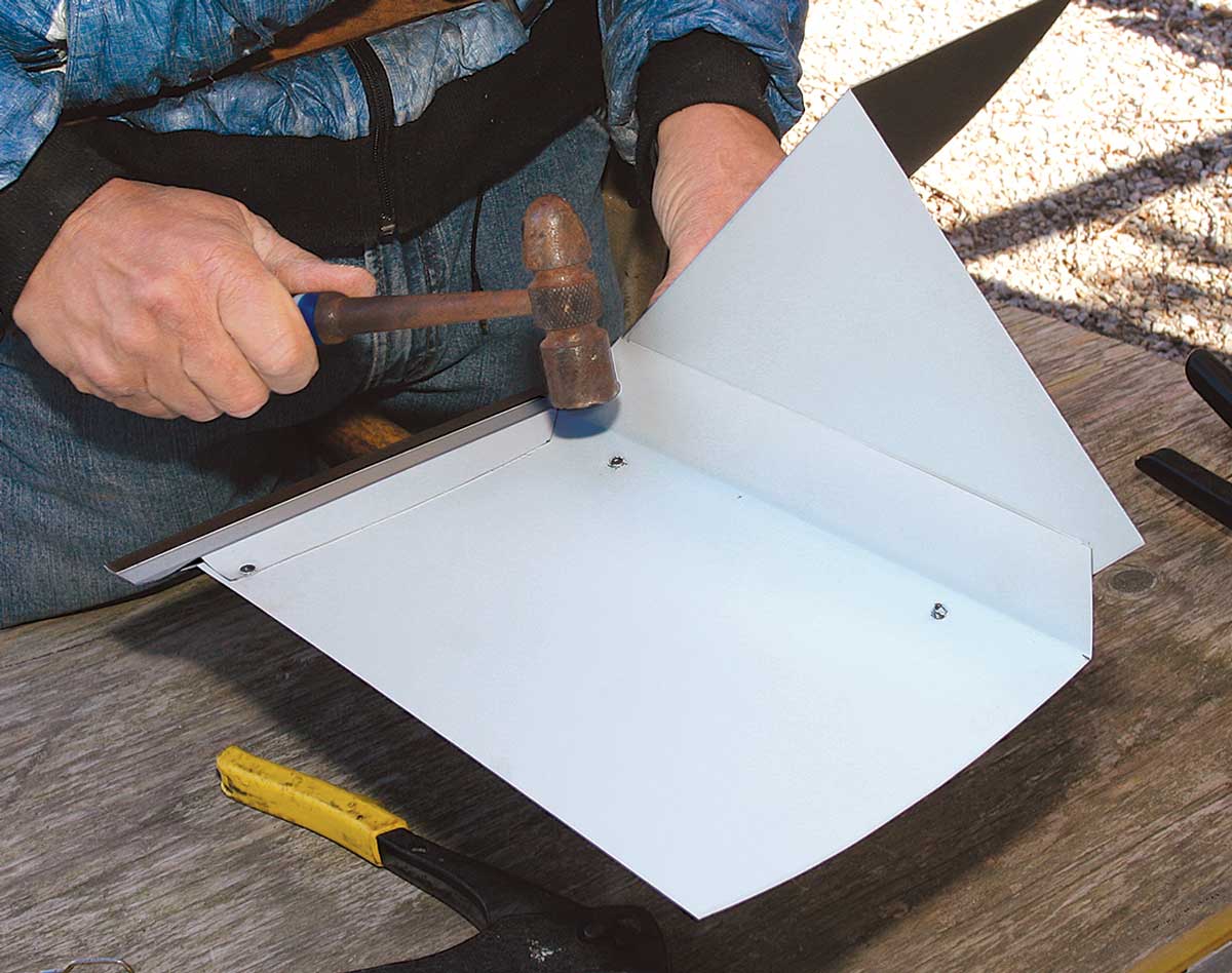 Pop goes the rivet. Pop rivets connect the two pieces. To keep the back of a rivet from pushing the assembly away from the wall, hammer it flat, using a second hammer below as an anvil.