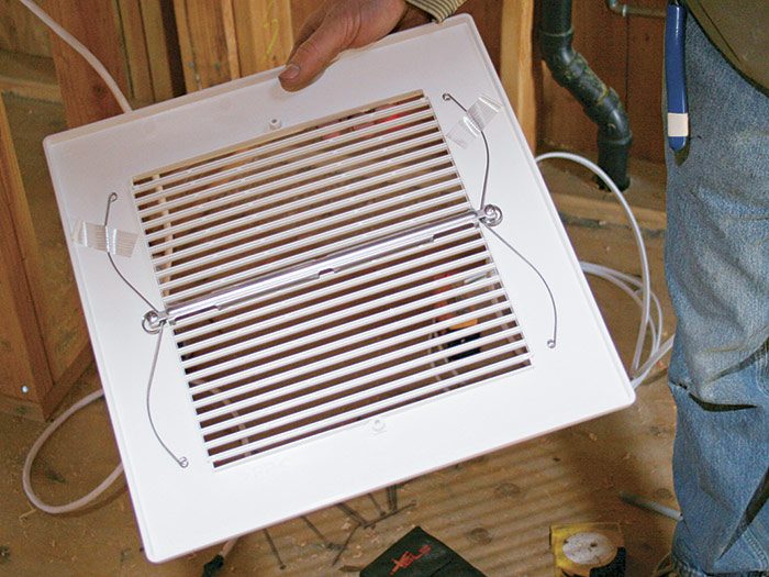 2  Install the trim piece to cover the gaps between the fan and the ceiling cutout.