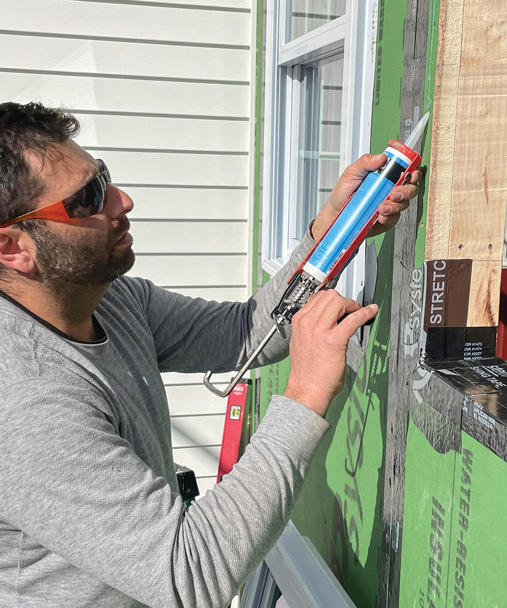 placing a bead of silicone sealant behind a window flange